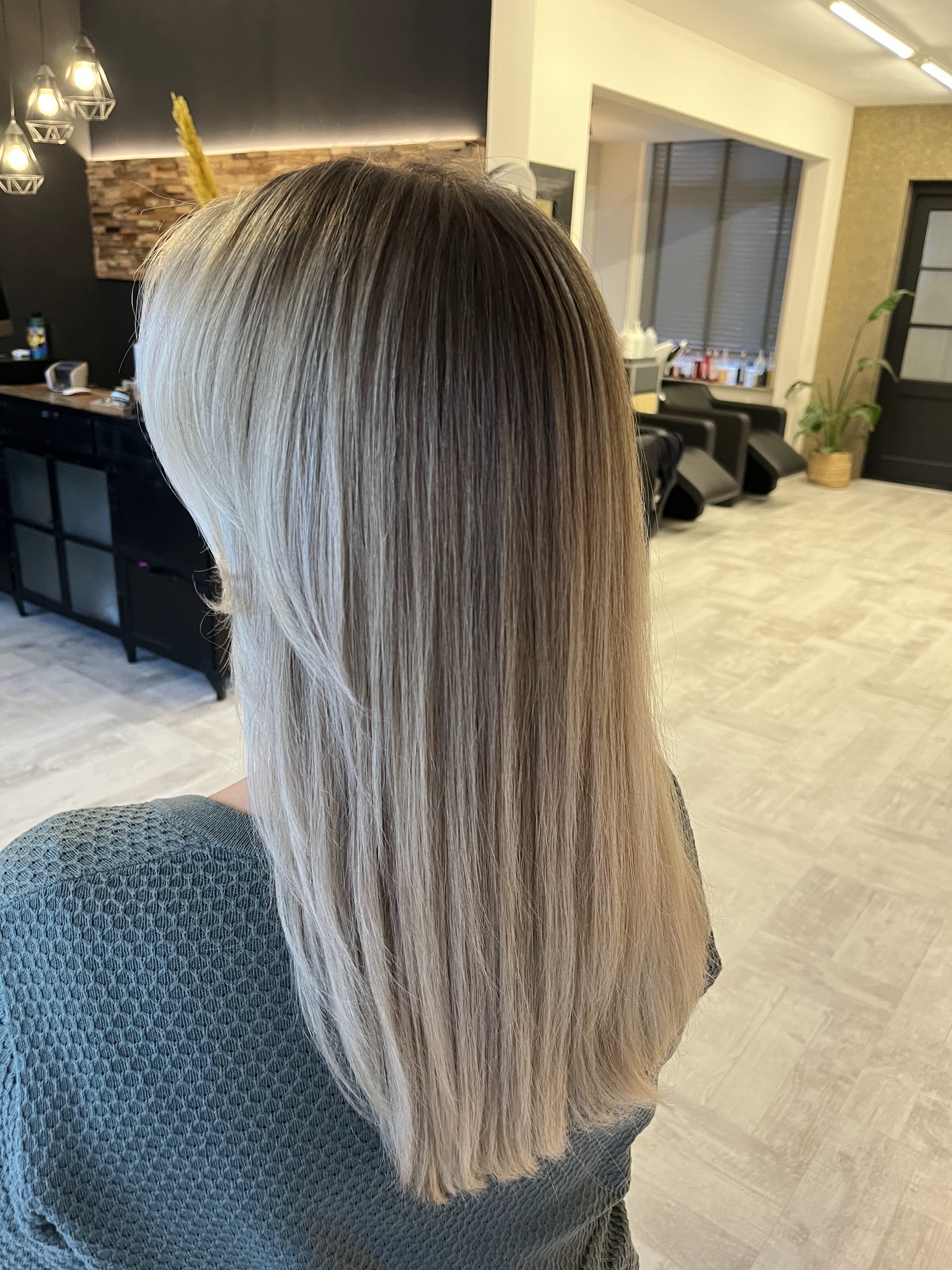 Lang, steil asblond haar met balayage, van achteren
